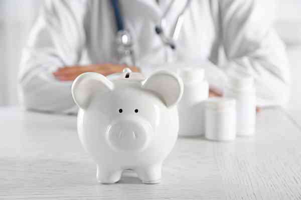 © Africa Studio - stock.adobe.com Arzt sitz hinter Sparschwein
